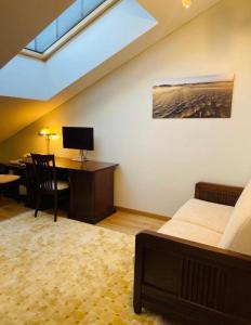 een slaapkamer met een bed en een bureau met een computer bij Jurmaris in Neringa