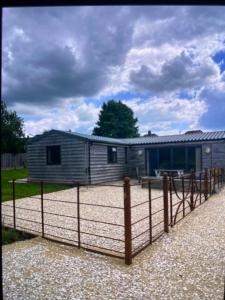 a small house with a fence in front of it at Private modern guest house in Yetminster