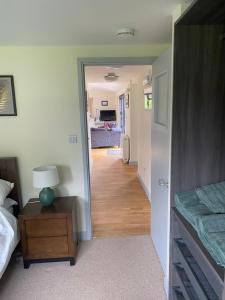 a bedroom with a bed and a room with a hallway at Private modern guest house in Yetminster