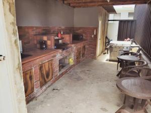 une cuisine avec un mur de briques, des tables et des chaises dans l'établissement Cozy 1BR Beachside Apartment Entre Olas, à Vega Baja