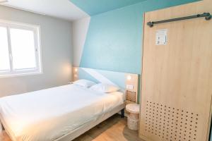 een slaapkamer met een wit bed en een raam bij Ibis budget Brest Sud Plougastel - Hôtel rénové in Plougastel-Daoulas +19 foto's