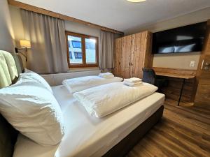 a hotel room with two beds and a flat screen tv at Apartment Gerlos 183 in Gerlos