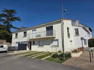 een wit gebouw met een balkon in een straat bij gîte du Cellier nantais in Le Cellier