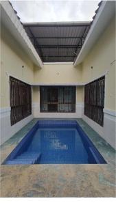 a large swimming pool in a room with a building at V Square Villa in Shenwa
