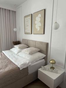 een slaapkamer met een bed en twee schilderijen aan de muur bij Nadmorski Apartament B5 in Gąski