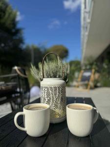 twee kopjes koffie bovenop een tafel bij Nadmorski Apartament B5 in Gąski