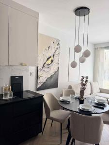 een keuken en woonkamer met een tafel en stoelen bij Nadmorski Apartament B5 in Gąski
