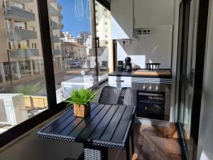 een balkon met een tafel en uitzicht op de stad bij Zizas House Studio in Praia da Rocha