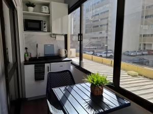 een kleine keuken met een tafel en een balkon bij Zizas House Studio in Praia da Rocha +2 foto's