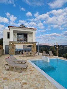 a villa with a swimming pool and a house at Seeview Villa and Mountain view in Grizókambos