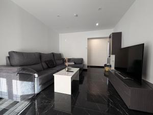 een woonkamer met een bank en een flatscreen-tv bij CASTELLON DELUXE in Castellón de la Plana