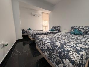 een kamer met drie bedden en een raam bij CASTELLON DELUXE in Castellón de la Plana