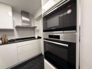 een keuken met een fornuis en een magnetron bij CASTELLON DELUXE in Castellón de la Plana