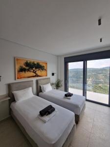 a hotel room with two beds and a large window at Seeview Villa and Mountain view in Grizókambos +107 photos