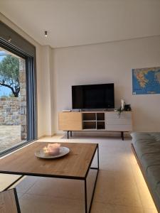 a living room with a tv and a table at Seeview Villa and Mountain view in Grizókambos