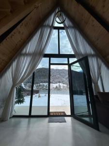 a room with a large window with white curtains at Sunshine Borjomi in Borjomi