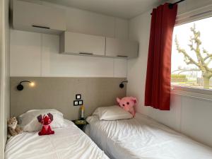 two beds in a room with stuffed animals on them at ULVF Les Beaupins in Saint-Denis-dʼOléron +32 photos