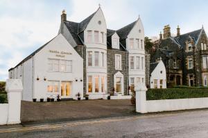 een groot wit huis met een zwart dak bij Muthu Queens Hotel, Oban in Oban