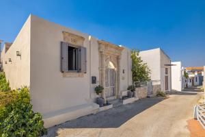 a white building with a window on a street at Melitia Traditional House in Koskinou