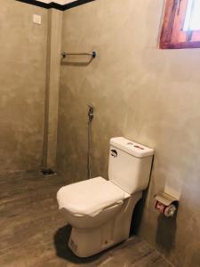 a bathroom with a white toilet in a room at Nimal's villa in Midigama East