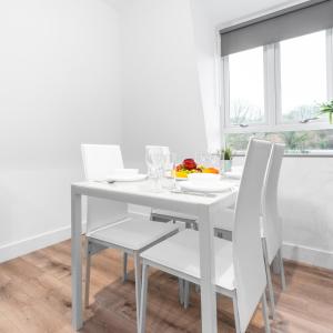 a white dining room with a white table and chairs at Modern Two Bed Apartment - Netflix - Balcony - Parking - 5MC in Birmingham