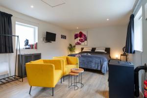 a bedroom with a bed and a yellow couch and a table at Bed and breakfast Stiens in Stiens