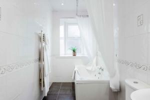 een witte badkamer met een bad en een wastafel bij Muthu Queens Hotel, Oban in Oban +39 foto's