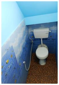 een badkamer met een toilet in een blauwe muur bij Le Casa Stay in Pondicherry +7 foto's
