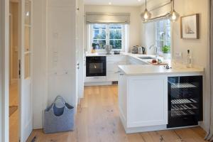 een keuken met witte kasten en een groot eiland bij Strandhafer in List +74 foto's