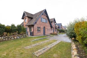 een groot bakstenen huis met een stenen pad in de tuin. bij Strandhafer in List