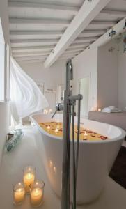 un bagno con vasca e candele di Alma Capodimonte Lake chalet a Capodimonte