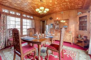 a dining room with a wooden table and chairs at Vanda Heritage Houseboats in Srinagar