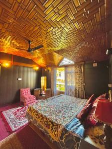a bedroom with a large bed with a wooden ceiling at Vanda Heritage Houseboats in Srinagar
