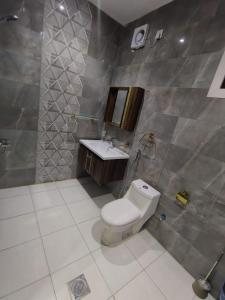 a bathroom with a toilet and a sink at العروسة للشقق المخدومة in Tabuk