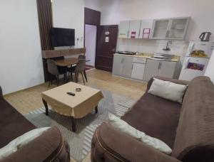 a living room with a couch and a table and a kitchen at العروسة للشقق المخدومة in Tabuk +1 photo