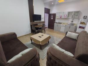 a living room with two couches and a table and a kitchen at العروسة للشقق المخدومة in Tabuk