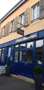 een gebouw met een blauwe deur en een restaurant bij LE Prana in Rozérieulles