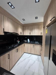 a kitchen with wooden cabinets and a black refrigerator at villa la pal de 4 in La Ureña +4 photos