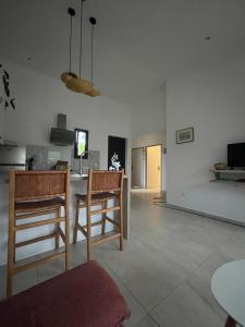 a living room with a table and some chairs at Case Ylang Blossom in Étang-Salé