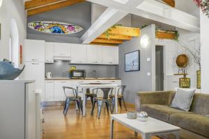 een keuken en woonkamer met een bank en een tafel bij Windshouse Apartments in Nago-Torbole