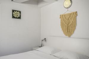 een witte slaapkamer met een bed en een spiegel bij Windshouse Apartments in Nago-Torbole