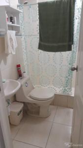 een badkamer met toilet en douchegordijn bij Aloha in San Bartolo