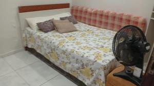 a bedroom with a bed and a fan at Seu Refúgio a 100m da Praia do Sobral - Maceió in Maceió