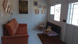 a living room with a couch and a table at Seu Refúgio a 100m da Praia do Sobral - Maceió in Maceió