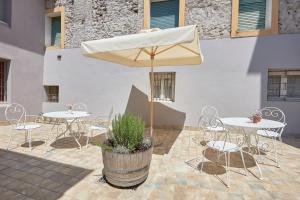 a patio with tables and chairs and an umbrella at Residence "Professor's nest" - Verona Apartments in Verona