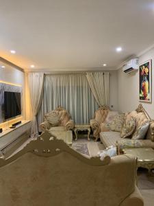a living room with two couches and a television at Gracepointapartments in Lekki