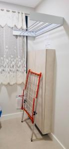 a red cart in a room with a curtain at Apartamento perto da Praia em Itapema!!! in Itapema