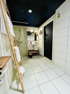 a bathroom with a white tiled floor and a shower at Hôtel les Chaumettes in Savines