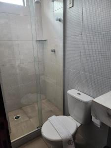 a bathroom with a toilet and a glass shower at Murano Suits Hotel in João Pessoa