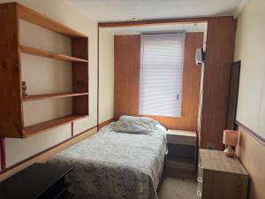 a small bedroom with a bed and a window at Family Summer House in Valparaíso